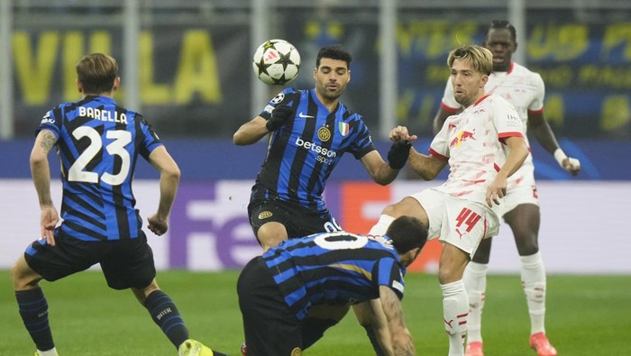 Inter Milans Mehdi Taremi, center, challenges for the ball with Leipzigs Kevin Kampl , right, during a Champions League opening phase soccer match between Inter Milan and Leipzig, at the San Siro stadium in Milan, Italy, Tuesday, Nov. 26, 2024. (AP Photo/Luca Bruno)