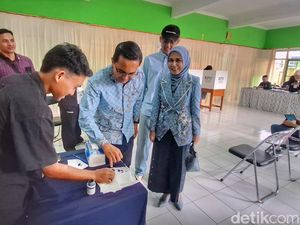 Kompak Berbatik Biru Muda, Sahrul dan Istri Nyobolos di TPS 14 Soreang