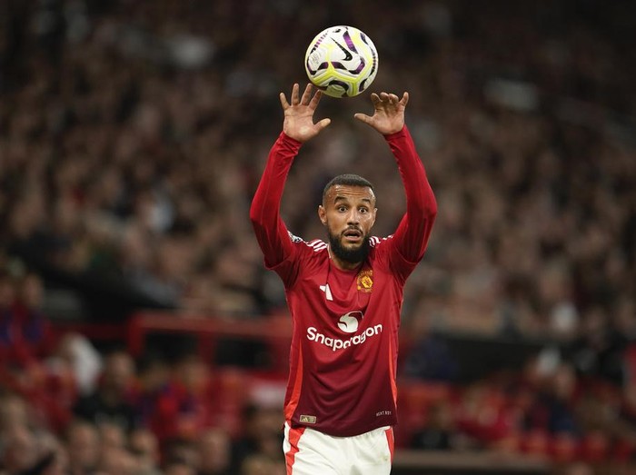 Manchester United's Noussair Mazraoui takes a throw-in during the English Premier League soccer match between Manchester United and Fulham at Old Trafford, Friday, Aug. 16, 2024, in Manchester, England. (AP Photo/Dave Thompson)