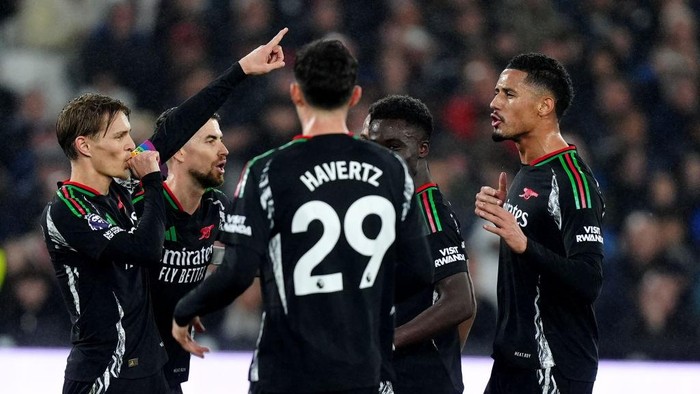 Arsenals Martin Odegaard (left) celebrates after scoring his sides third goal from the penalty spot during the Premier League match at the London Stadium, London. Picture date: Saturday November 30, 2024. (Photo by Mike Egerton/PA Images via Getty Images)