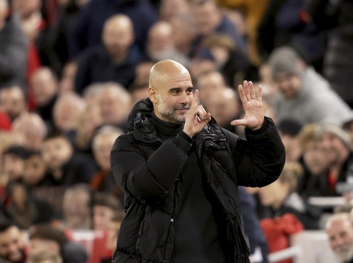 Manchester City's head coach Pep Guardiola puts up six fingers to remind the jeering fans of his six Premier League titles at the end of the English Premier League soccer match between Liverpool and Manchester City at Anfield Stadium, Liverpool, England, Sunday Dec. 1, 2024. (AP Photo/Ian Hodgson)