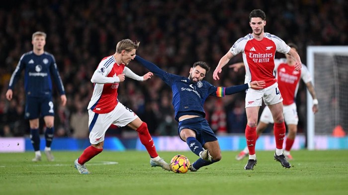 LONDON, ENGLAND - DECEMBER 04: Martin Odegaard of Arsenal is challenged by Bruno Fernandes of Manchester United during the Premier League match between Arsenal FC and Manchester United FC at Emirates Stadium on December 04, 2024 in London, England. (Photo by Shaun Botterill/Getty Images)