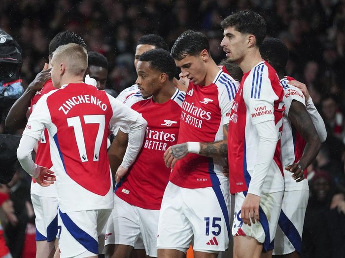 Arsenal's Jurrien Timber, center, celebrates with teammates after scoring his side's first goal during the English Premier League soccer match between Arsenal and Manchester United at Emirates stadium in London, Wednesday, Dec. 4, 2024. (AP Photo/Kirsty Wigglesworth)