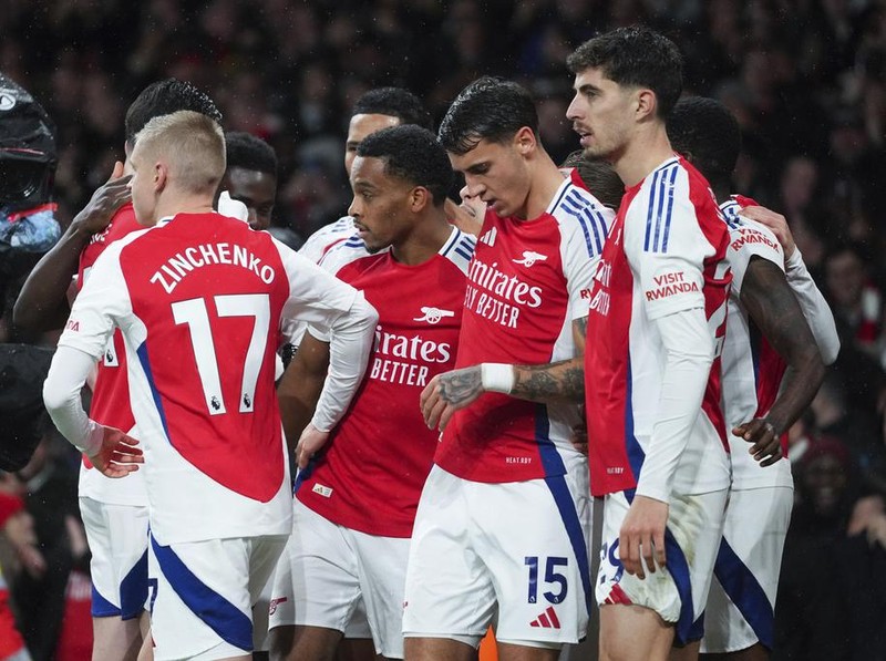 Arsenal's Jurrien Timber, center, celebrates with teammates after scoring his side's first goal during the English Premier League soccer match between Arsenal and Manchester United at Emirates stadium in London, Wednesday, Dec. 4, 2024. (AP Photo/Kirsty Wigglesworth)