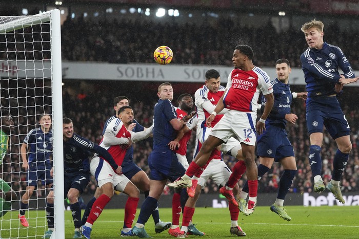 Arsenal's Jurrien Timber, center right, heads the ball to score his side's first goal during the English Premier League soccer match between Arsenal and Manchester United at Emirates stadium in London, Wednesday, Dec. 4, 2024. (AP Photo/Kirsty Wigglesworth)