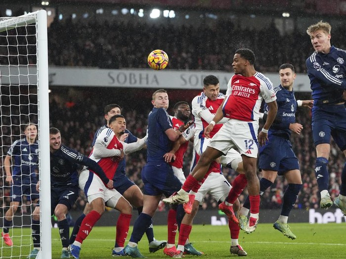 Arsenal's Jurrien Timber, center right, heads the ball to score his side's first goal during the English Premier League soccer match between Arsenal and Manchester United at Emirates stadium in London, Wednesday, Dec. 4, 2024. (AP Photo/Kirsty Wigglesworth)