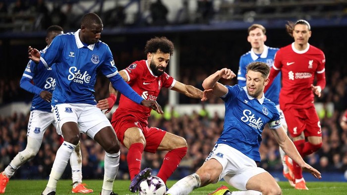 LIVERPOOL, ENGLAND - MARCH 16: Mohamed Salah of Liverpool is tackled by Abdoulaye Doucoure and James Tarkowski of Everton during the Premier League match between Everton FC and Liverpool FC at Goodison Park on March 16, 2024 in Liverpool, England.(Photo by Daniel Chesterton/Offside/Offside via Getty Images)