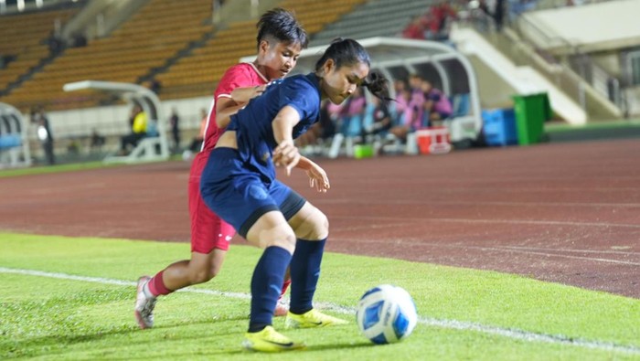 Pesepak bola Timnas Putri Indonesia Claudia Scheunamann (kanan) melewati hadangan pesepak bola Timnas Putri Kamboja Keo Channa (tengah) dalam babak final Piala AFF 2024 Putri di di New Laos National Stadium, Vientiane, Laos, Kamis (5/12/2024).
