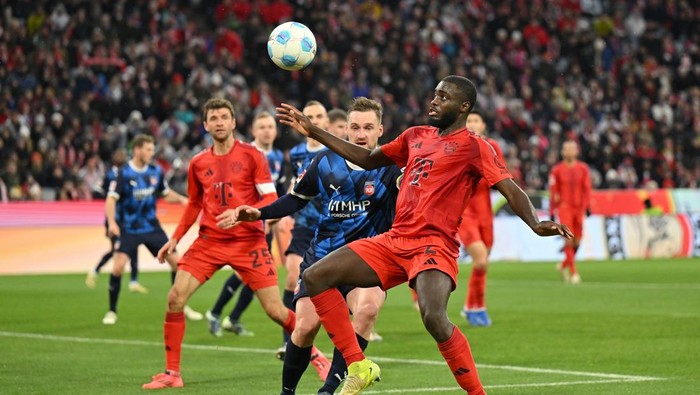 MUNICH, GERMANY - DECEMBER 07: Dayot Upamecano of Bayern Munich controls the ball under pressure from Patrick Mainka of 1.FC Heidenheim 1846 during the Bundesliga match between FC Bayern München and 1. FC Heidenheim 1846 at Allianz Arena on December 07, 2024 in Munich, Germany. (Photo by Sebastian Widmann/Getty Images)