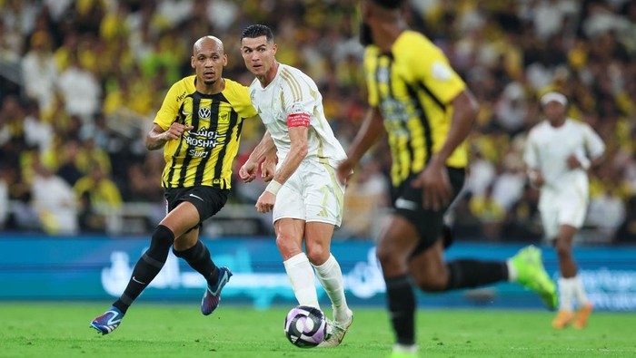 JEDDAH, SAUDI ARABIA - DECEMBER 6: Cristiano Ronaldo of Al Nassr rchallenged by Fabinho of Al Ittihad during the Saudi Pro League match between Al-Ittihad v Al-Nassr at King Abdullah Sports City on December 6, 2024 in Jeddah, Saudi Arabia. (Photo by Yasser Bakhsh/Getty Images)
