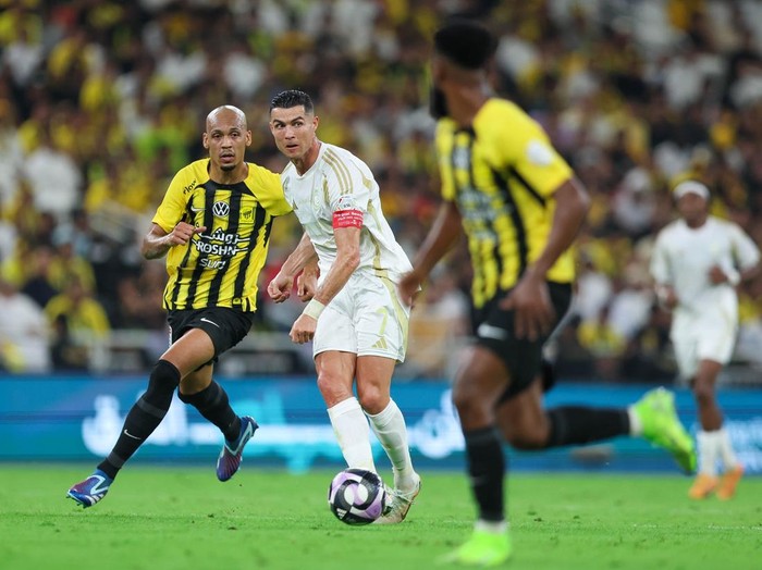 JEDDAH, SAUDI ARABIA - DECEMBER 6: Cristiano Ronaldo of Al Nassr rchallenged by Fabinho of Al Ittihad during the Saudi Pro League match between Al-Ittihad v Al-Nassr at King Abdullah Sports City on December 6, 2024 in Jeddah, Saudi Arabia. (Photo by Yasser Bakhsh/Getty Images)