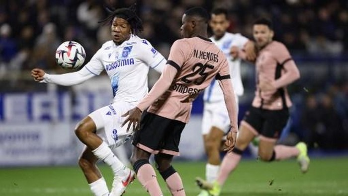 Auxerres Nigerian defender Gabriel Osho (L) fights for the ball with Paris Saint-Germains Portuguese defender #25 Nuno Mendes (R) during the French L1 football match between AJ Auxerre and Paris Saint-Germain (PSG) at Stade de lAbbe-Deschamps in Auxerre, central France on December 6, 2024. (Photo by FRANCK FIFE / AFP)