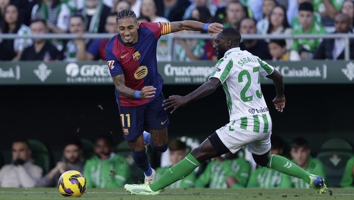 SEVILLA, SPAIN - DECEMBER 7: (L-R) Raphinha of FC Barcelona, Youssouf Sabaly of Real Betis Sevilla  during the LaLiga EA Sports  match between Real Betis Sevilla v FC Barcelona at the Estadio Benito Villamarin on December 7, 2024 in Sevilla Spain (Photo by Eric Verhoeven/Soccrates/Getty Images)