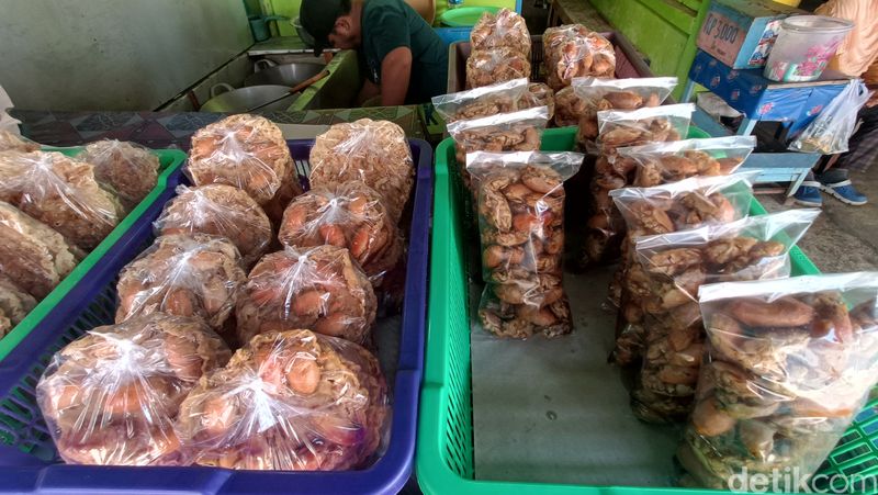 Agus menata peyek yutuk yang baru dimasak di lapaknya sekitar Pantai Widarapayung, Kabupaten Cilacap, Minggu (8/12/2024).