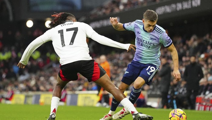 Arsenals Leandro Trossard, right, challenges for the ball with Fulhams Alex Iwobi during the English Premier League soccer match between Fulham and Arsenal, at the Craven Cottage Stadium in London, Sunday, Dec. 8, 2024. (AP Photo/Dave Shopland)