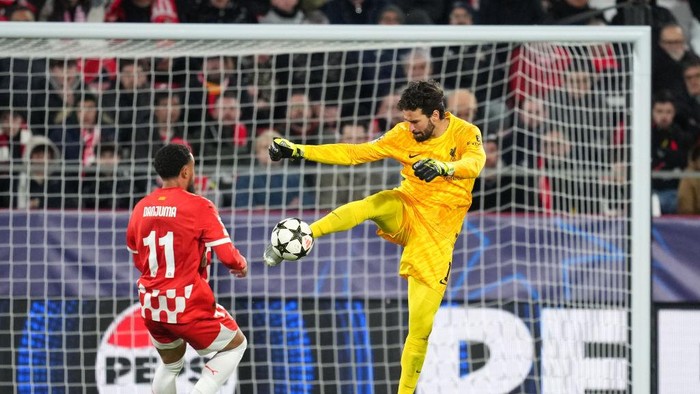 GIRONA, SPAIN - DECEMBER 10: Alisson Becker of Liverpool clears the ball under pressure from Arnaut Danjuma of Girona FC during the UEFA Champions League 2024/25 League Phase MD6 match between Girona FC and Liverpool FC at Montilivi Stadium on December 10, 2024 in Girona, Spain. (Photo by Alex Caparros - UEFA/UEFA via Getty Images)