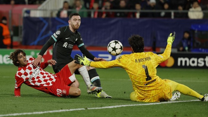 Liverpools goalkeeper Alisson stops the ball to make a save after an attempt by Gironas Bryan Gil, left, during the Champions League soccer match between Girona and Liverpool at the Estadi Montilivi in Girona, Spain, Tuesday, Dec. 10, 2024. (AP Photo/Joan Monfort)