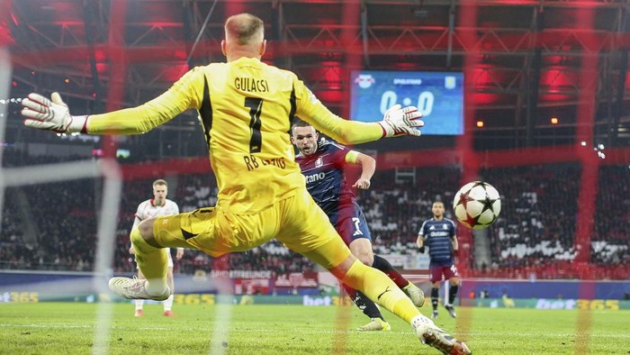 Aston Villas John McGinn scores past Leipzig goalkeeper Peter Gulacsi  during a UEFA Champions League soccer match at the Red Bull Arena, Tuesday, Dec. 10, 2024, Leipzig, Germany.  (Jan Woitas/dpa via AP)