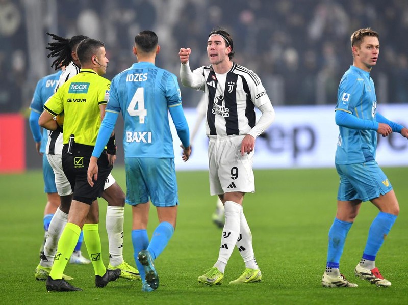 TURIN, ITALY - DECEMBER 14: Dusan Vlahovic of Juventus exchanges words with Jay Idzes of Venezia after scoring his team's second goal from a penalty kick during the Serie A match between Juventus and Venezia at Allianz Stadium on December 14, 2024 in Turin, Italy. (Photo by Valerio Pennicino/Getty Images)