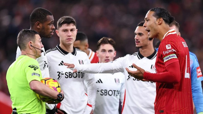 LIVERPOOL, ENGLAND - DECEMBER 14: Virgil van Dijk of Liverpool speaks with Referee Tony Harrington during the Premier League match between Liverpool FC and Fulham FC at Anfield on December 14, 2024 in Liverpool, England. (Photo by Robbie Jay Barratt - AMA/Getty Images)