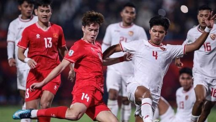 Vietnams Hoang Duc Nguyen (C) and Indonesias Kadek Arel Priyatna (R) fight for the ball during the 2024 ASEAN Electric Cup group B football match between Vietnam and Indonesia at the Viet Tri stadium in Phu Tho province on December 15, 2024. (Photo by Lam THOA / AFP)