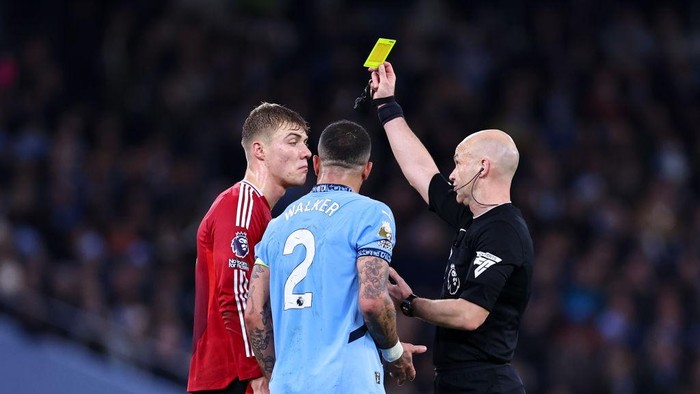 MANCHESTER, ENGLAND - DECEMBER 15: Rasmus Højlund of Manchester United and Kyle Walker of Manchester City receive a yellow card from Referee Anthony Taylor during the Premier League match between Manchester City FC and Manchester United FC at Etihad Stadium on December 15, 2024 in Manchester, England. (Photo by Robbie Jay Barratt - AMA/Getty Images)