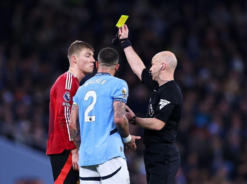 MANCHESTER, ENGLAND - DECEMBER 15: Rasmus Højlund of Manchester United and Kyle Walker of Manchester City receive a yellow card from Referee Anthony Taylor during the Premier League match between Manchester City FC and Manchester United FC at Etihad Stadium on December 15, 2024 in Manchester, England. (Photo by Robbie Jay Barratt - AMA/Getty Images)