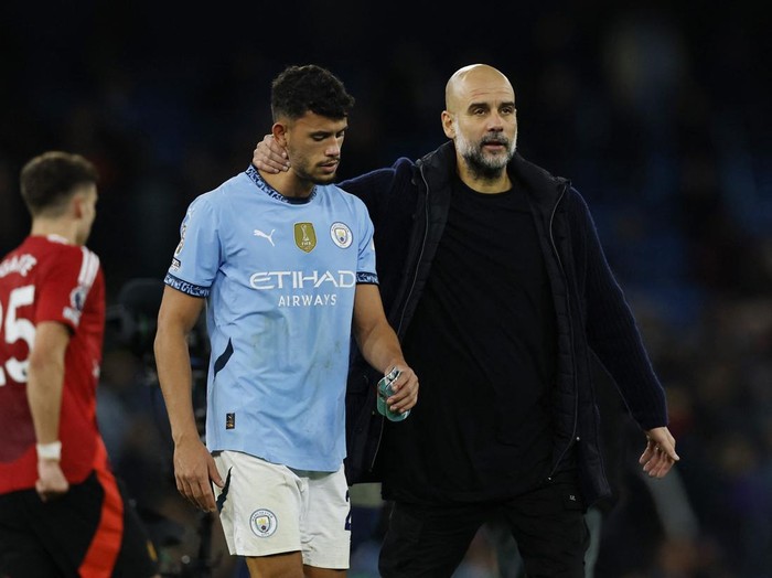 Soccer Football - Premier League - Manchester City v Manchester United - Etihad Stadium, Manchester, Britain - December 15, 2024 Manchester City's Matheus Nunes looks dejected with manager Pep Guardiola after the match Action Images via Reuters/Jason Cairnduff EDITORIAL USE ONLY. NO USE WITH UNAUTHORIZED AUDIO, VIDEO, DATA, FIXTURE LISTS, CLUB/LEAGUE LOGOS OR 'LIVE' SERVICES. ONLINE IN-MATCH USE LIMITED TO 120 IMAGES, NO VIDEO EMULATION. NO USE IN BETTING, GAMES OR SINGLE CLUB/LEAGUE/PLAYER PUBLICATIONS. PLEASE CONTACT YOUR ACCOUNT REPRESENTATIVE FOR FURTHER DETAILS..