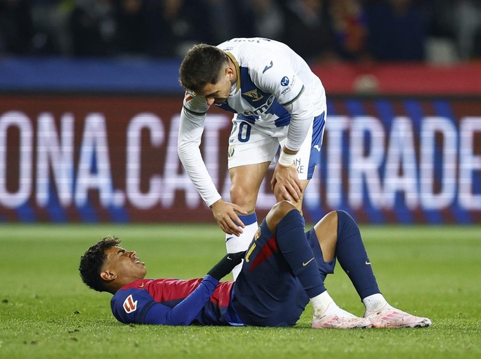 Soccer Football - LaLiga - FC Barcelona v Leganes - Estadi Olimpic Lluis Companys, Barcelona, Spain - December 15, 2024  FC Barcelona's Lamine Yamal reacts after sustaining an injury as Leganes' Javi Hernandez looks on REUTERS/Albert Gea