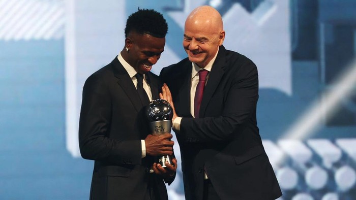 Senyum Bahagia Vinicius Junior Jadi Pemain Pria Terbaik FIFA 2024 DOHA, QATAR - DECEMBER 17: Vinicius Junior of Real Madrid, seen with The Best FIFA Men's Player Award, leaves the venue with Florentino Perez, President of Real Madrid, following the The Best FIFA Football Awards 2024 at Aspire Academy on December 17, 2024 in Doha, Qatar. (Photo by Christopher Pike - FIFA/FIFA via Getty Images)