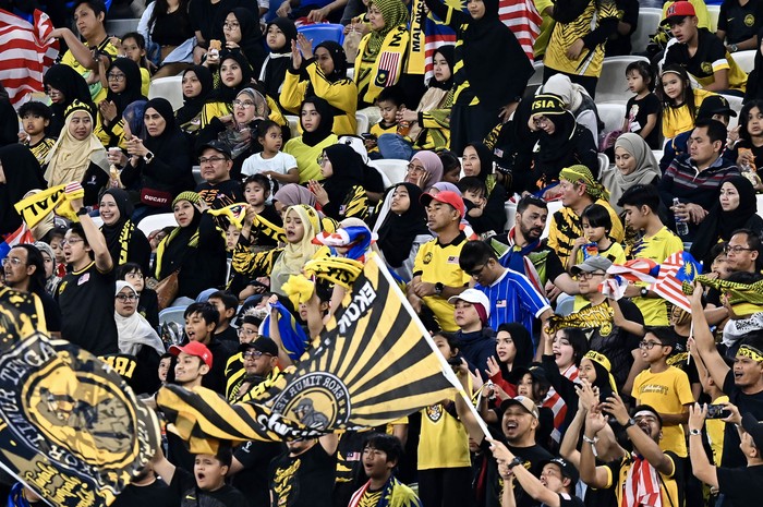 Malaysian supporters are cheering for their team at the AFC U23 Asian Cup Qatar 2024 Group D match between Kuwait and Malaysia at Al Janoub Stadium in Doha, Qatar, on April 23, 2024. (Photo by Noushad Thekkayil/NurPhoto via Getty Images)