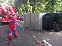 Mobil Boks Angkut Aki Terguling di Ketabang Kali Surabaya, 2 Orang Luka