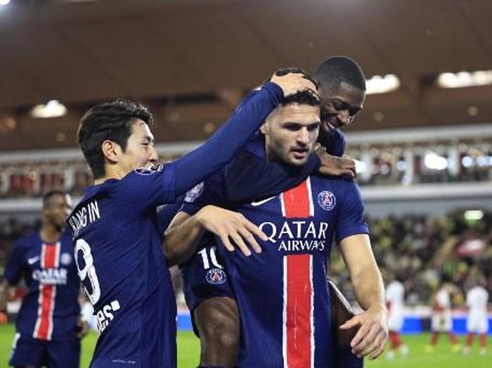 Paris Saint-Germain's Portuguese forward #09 Goncalo Ramos (C) celebrates scoring his team's third goal with Paris Saint-Germain's French forward #10 Ousmane Dembele (R) and Paris Saint-Germain's South Korean midfielder #19 Lee Kang-in during the French L1 football match between AS Monaco and Paris Saint-Germain at the Louis II Stadium (Stade Louis II) in the Principality of Monaco on December 18, 2024. (Photo by Valery HACHE / AFP)