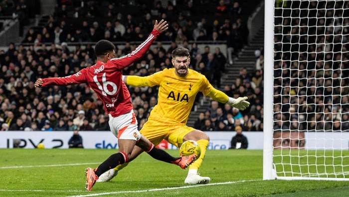 LONDON, ENGLAND - DECEMBER 19: Manchester Uniteds Amad Diallo (left) shoots at goal under pressure from Tottenham Hotspurs goalkeeper Fraser Forster during the Carabao Cup Quarter Final match between Tottenham Hotspur and Manchester United at Tottenham Hotspur Stadium on December 19, 2024 in London, England. (Photo by Andrew Kearns - CameraSport via Getty Images)