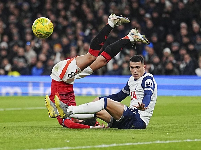 Tottenham's Pedro Porro, right, challenges for the ball with Manchester United's Bruno Fernandes during the English League Cup quarter-final soccer match between Tottenham and Manchester United, at the Tottenham Hotspur Stadium in London, Thursday, Dec. 19, 2024. (AP Photo/Dave Shopland )