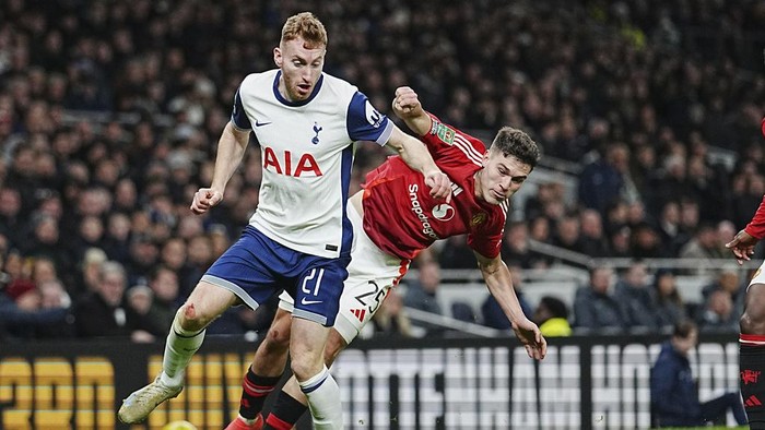 Tottenhams Dejan Kulusevski, left, challenges for the ball with Manchester Uniteds Manuel Ugarte during the English League Cup quarter-final soccer match between Tottenham and Manchester United, at the Tottenham Hotspur Stadium in London, Thursday, Dec. 19, 2024. (AP Photo/Dave Shopland )