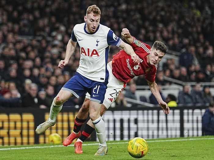 Tottenhams Dejan Kulusevski, left, challenges for the ball with Manchester Uniteds Manuel Ugarte during the English League Cup quarter-final soccer match between Tottenham and Manchester United, at the Tottenham Hotspur Stadium in London, Thursday, Dec. 19, 2024. (AP Photo/Dave Shopland )