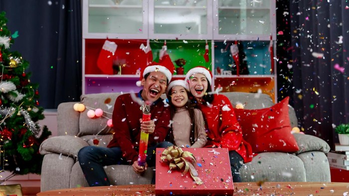 Ilustrasi Natal dan Tahun Baru Merry Christmas, Asian young family celebrate Christmas and new year party, Christmas playing confetti poppers