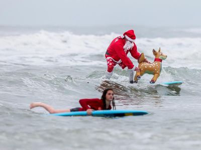 Aksi Sinterklas Berselancar Rayakan Natal