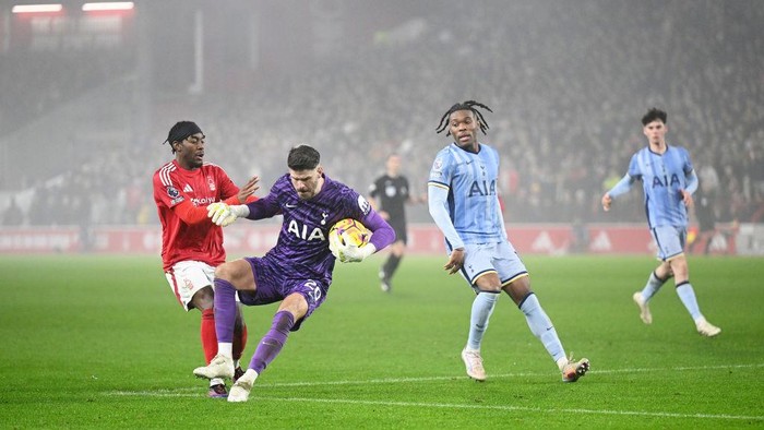 NOTTINGHAM, ENGLAND - DECEMBER 26: Fraser Forster of Tottenham Hotspur holds the ball whilst under pressure from Anthony Elanga of Nottingham Forest during the Premier League match between Nottingham Forest FC and Tottenham Hotspur FC at City Ground on December 26, 2024 in Nottingham, England. (Photo by Michael Regan/Getty Images)