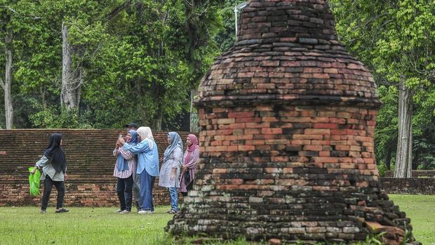 Sejumlah turis mendatangi Candi Tinggi dalam Kawasan Cagar Budaya Nasional (KCBN) Muarajambi di Muaro Jambi, Jambi, Kamis (26/12/2024). Kawasan situs cagar budaya yang diperkirakan dibangun pada era ke-6 dan menjadi tempat pendidikan Buddha paling besar di Asia Tenggara atau seluas 3.981 hektare itu menjadi opsi sebagian warga untuk mempergunakan waktu libur Natal 2024 dan Tahun Baru 2025 dengan kunjungan rata-rata per hari 500 orang lebih. ANTARA FOTO/Wahdi Septiawan/YU