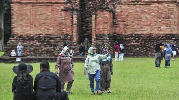 Sejumlah turis mendatangi Candi Tinggi dalam Kawasan Cagar Budaya Nasional (KCBN) Muarajambi di Muaro Jambi, Jambi, Kamis (26/12/2024). Kawasan situs cagar budaya yang diperkirakan dibangun pada era ke-6 dan menjadi tempat pendidikan Buddha paling besar di Asia Tenggara atau seluas 3.981 hektare itu menjadi opsi sebagian warga untuk mempergunakan waktu libur Natal 2024 dan Tahun Baru 2025 dengan kunjungan rata-rata per hari 500 orang lebih. ANTARA FOTO/Wahdi Septiawan/YU