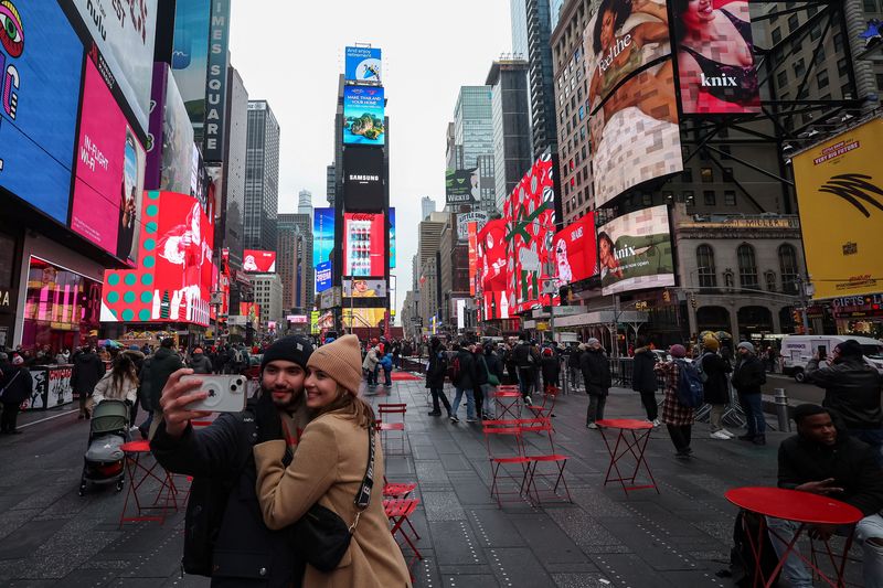 Bingkai Sepekan: Semarak Libur Nataru People take a selfie in Times Square in Manhattan in New York City, U.S., December 24, 2024. REUTERS/Marko Djurica