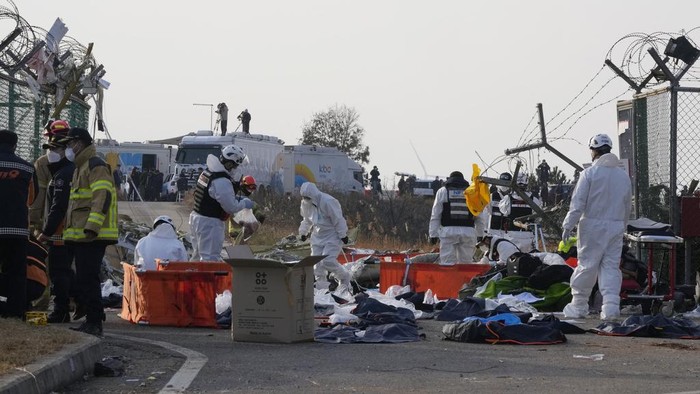 Firefighters and rescue team members work near the wreckage of a passenger plane at Muan International Airport in Muan, South Korea, Sunday, Dec. 29, 2024. (AP Photo/Ahn Young-joon)