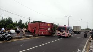 Truk Trailer Muat Kontainer Terguling di Layang Trosobo
