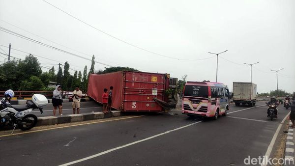 Truk Trailer Muat Kontainer Terguling di Layang Trosobo
