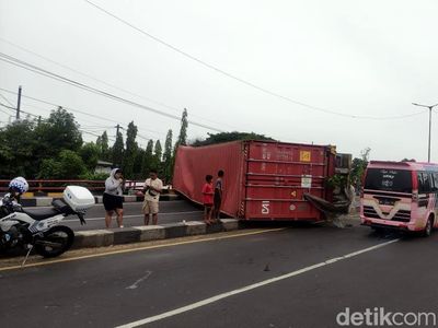 Truk Trailer Muat Kontainer Terguling di Layang Trosobo