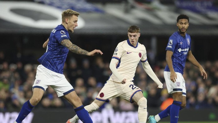 Ipswich Towns Luke Woolfenden, left, looks to pass the ball under pressure from Chelseas Cole Palmer during the English Premier League soccer match between Ipswich Town and Chelsea at Portman Road stadium in Ipswich, England, Monday, Dec. 30, 2024. (AP Photo/Richard Pelham)