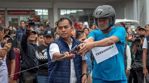 Personel kepolisian mengukur jarak tembak pelaku penembak pelajar hingga tewas, Aipda Robig Zainudin (kanan) saat memperagakan adegan penembakan pelajar dalam rekonstruksi kasus di Kelurahan Kalipancur, Kecamatan Ngaliyan, Kota Semarang, Jawa Tengah, Senin (30/12/2024). Ditreskrimum Polda Jateng menggelar 43 adegan rekonstruksi di enam lokasi kejadian dengan menghadirkan Aipda Robig Zainudin sebagai tersangka penembakan dan 11 saksi termasuk almarhum GRO dan satu saksi lain berinisial B yang perannya digantikan, untuk mendapatkan gambaran utuh dari peristiwa penembakan tersebut. ANTARA FOTO/Aji Styawan/rwa.