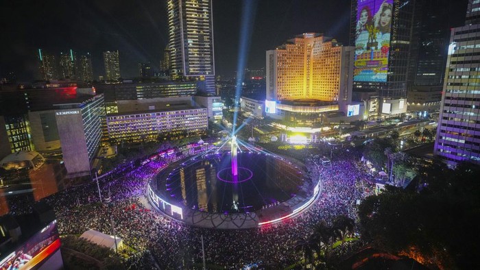 People gather in the main business district on New Years Eve in Jakarta, Indonesia, Tuesday, Dec. 31, 2024. (AP Photo/Tatan Syuflana) uji coba